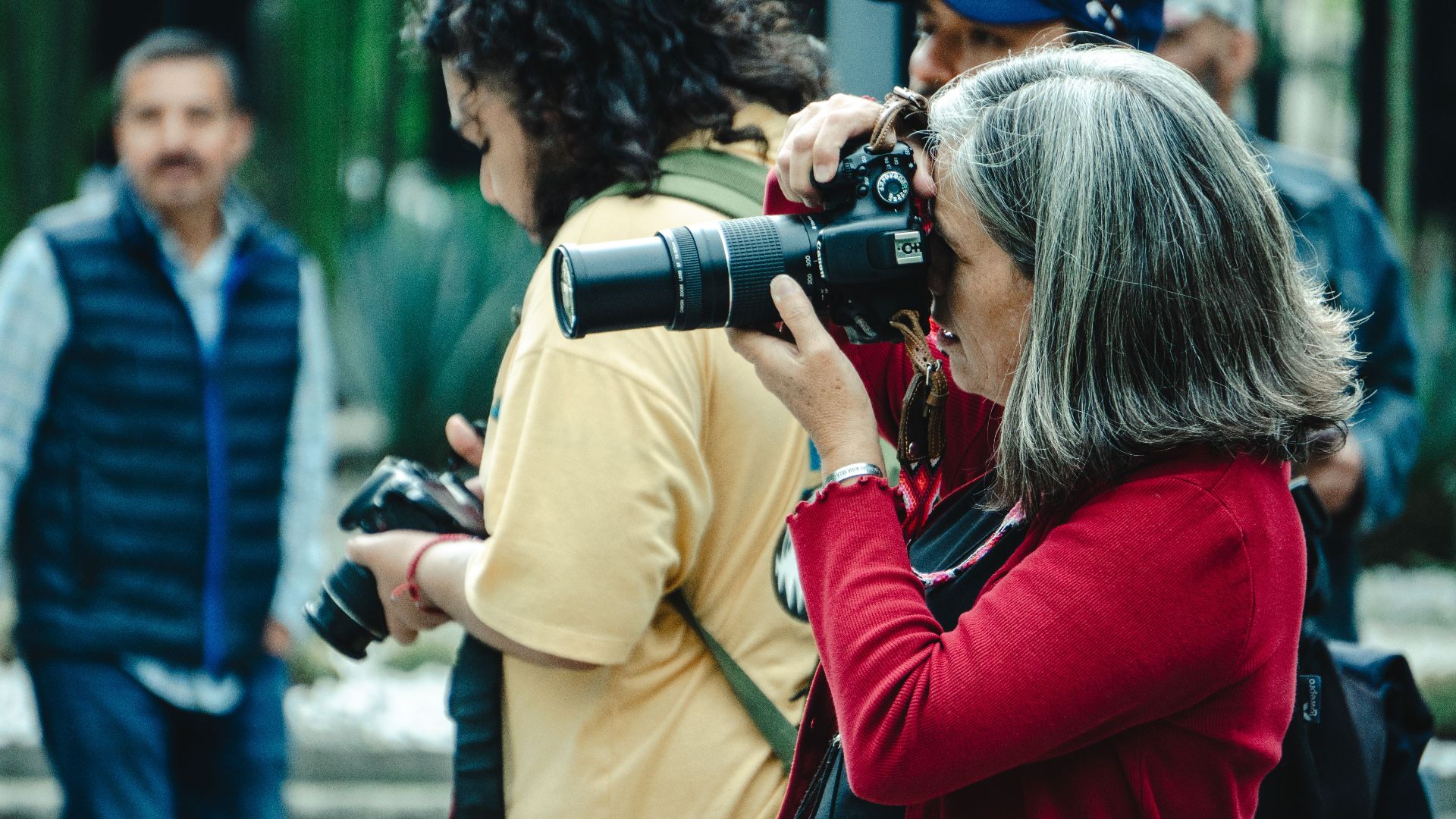 A group of men and women photographers capturing moments outdoors in Mexico City.