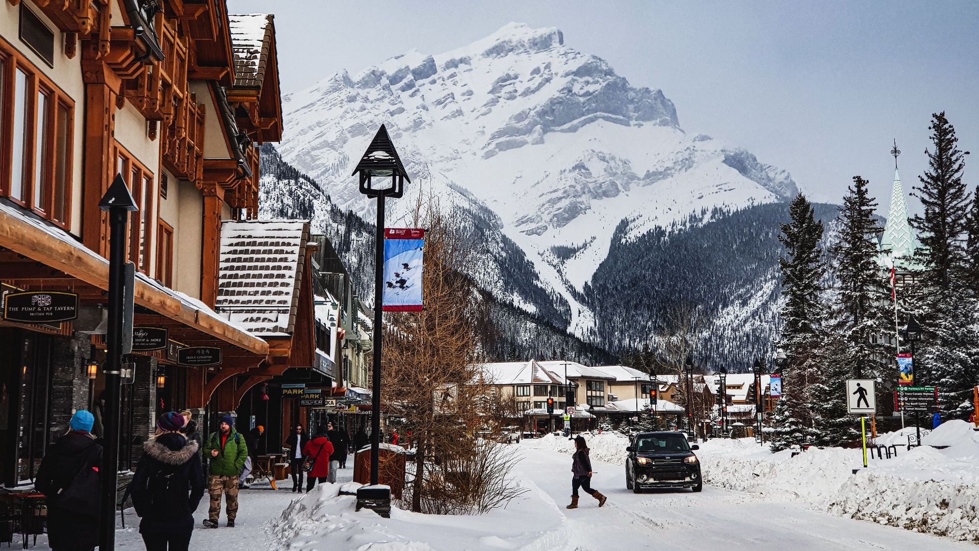 Charming winter landscape in Banff with snow-covered mountains and town streets.