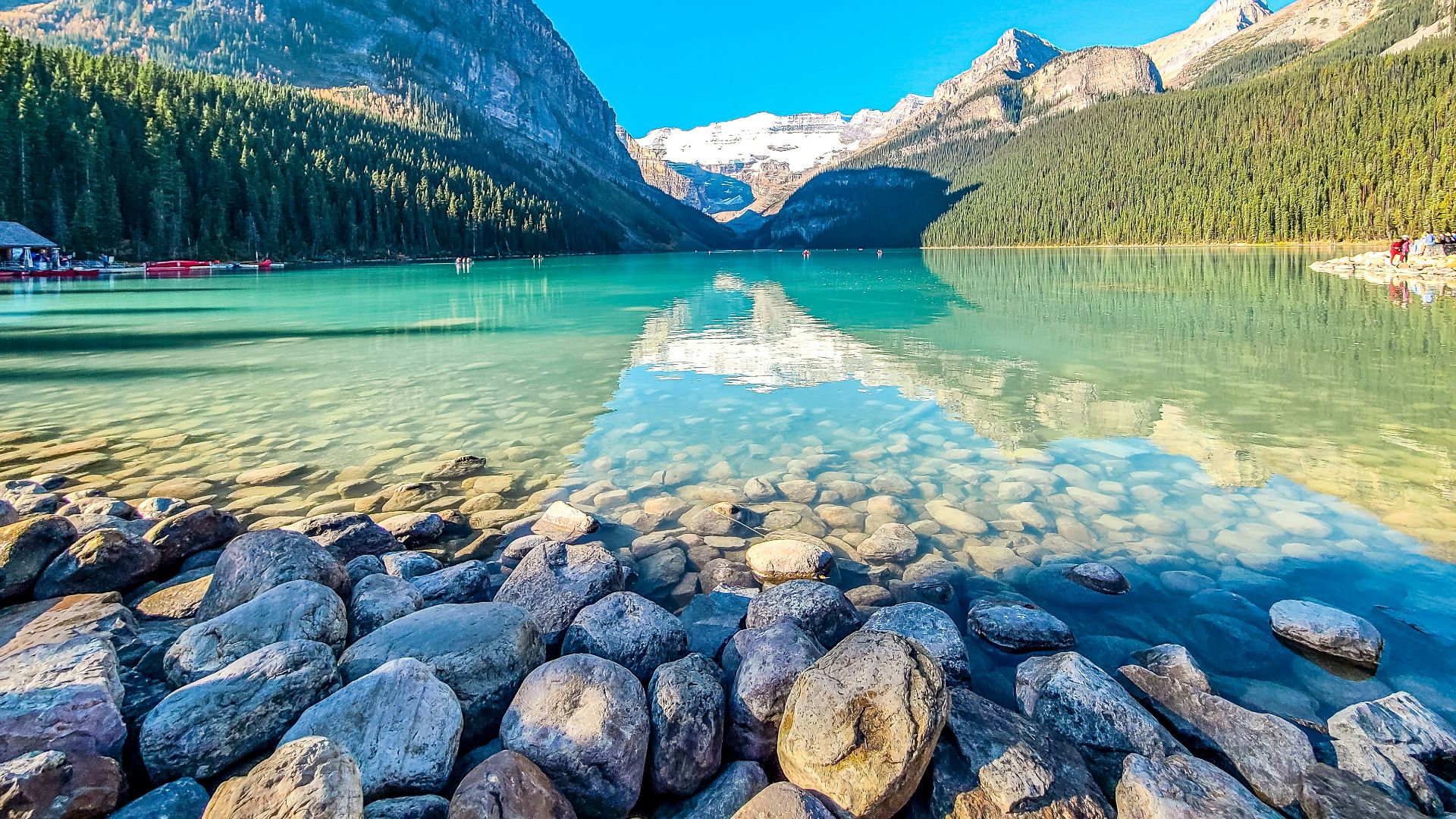 a lake surrounded by mountains and a forest