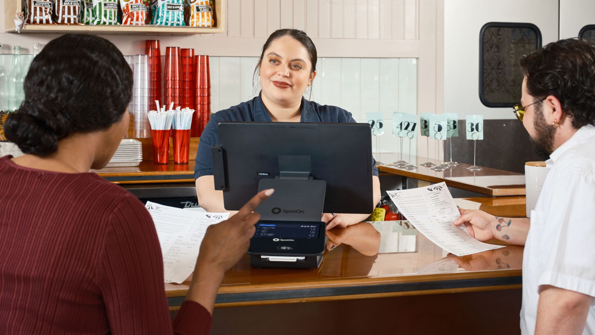 Restaurant staff take orders at a POS system, showcasing modern dining technology.