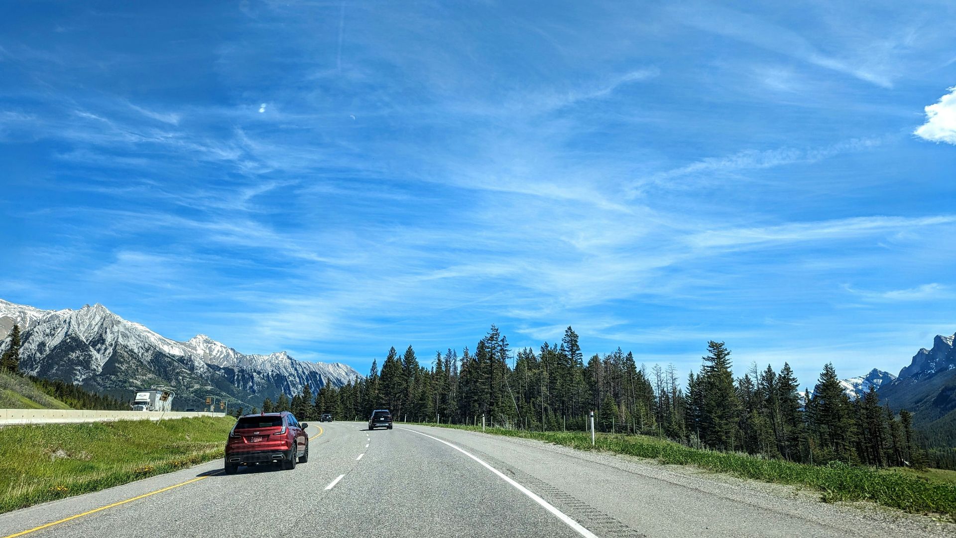 A car driving down a road with mountains in the background