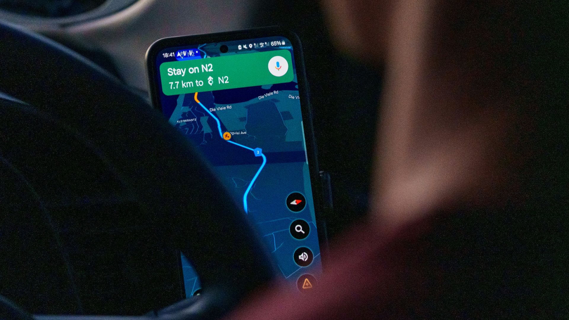 Person using navigation app on smartphone inside car.