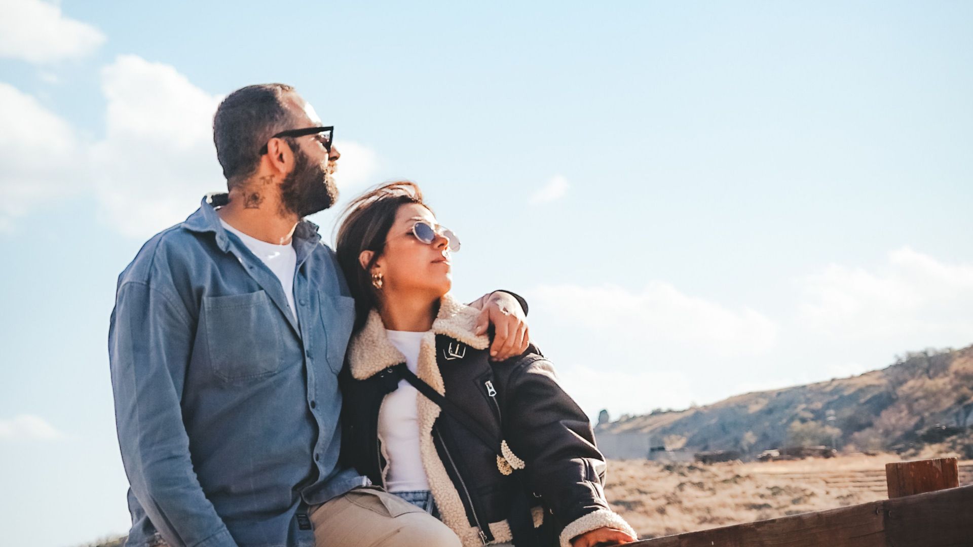 A couple standing closely together on a pier, enjoying a serene view. Perfect for travel and romance themes.
