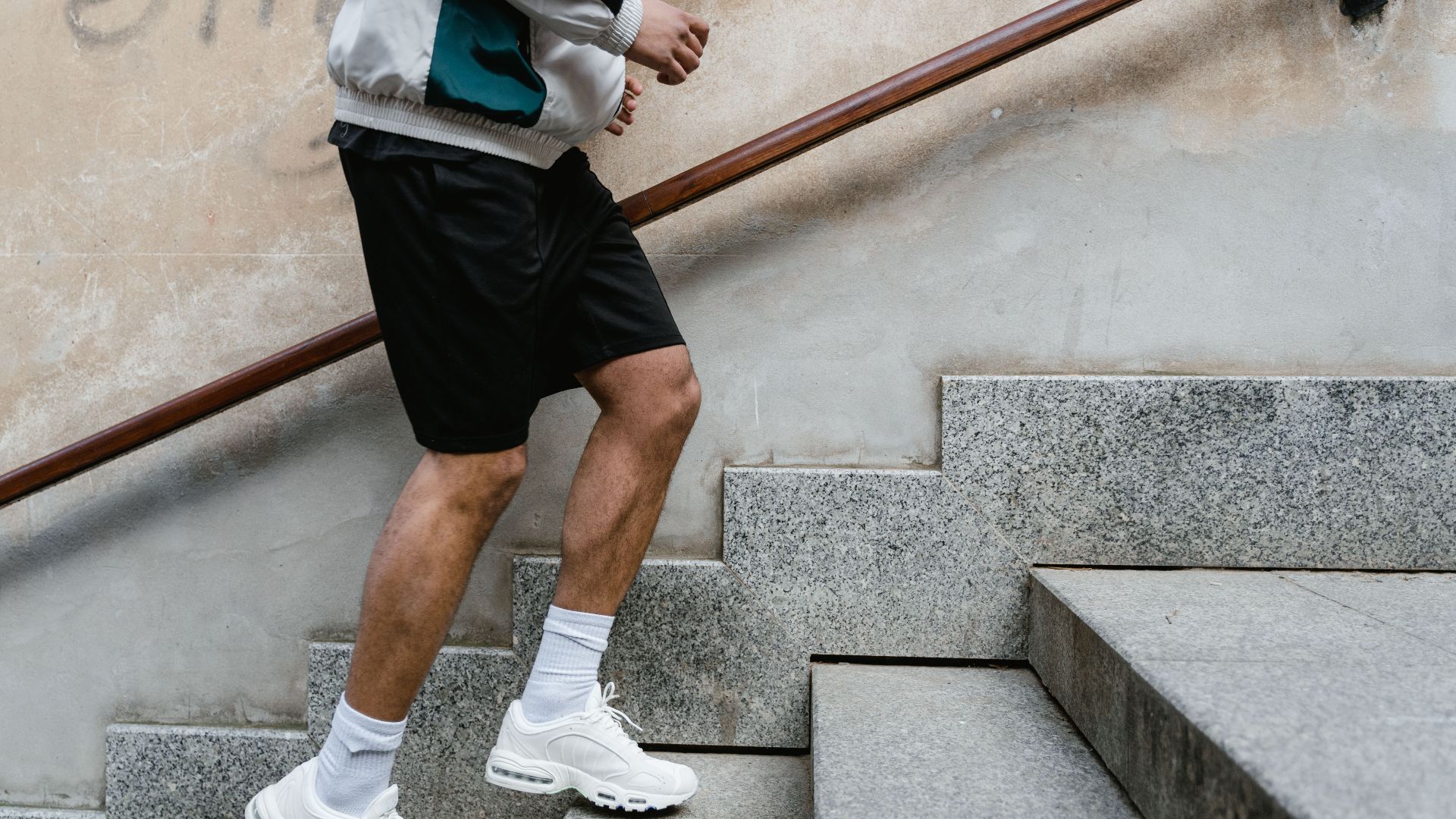 Close-up of a man running upstairs for fitness exercise outdoors.
