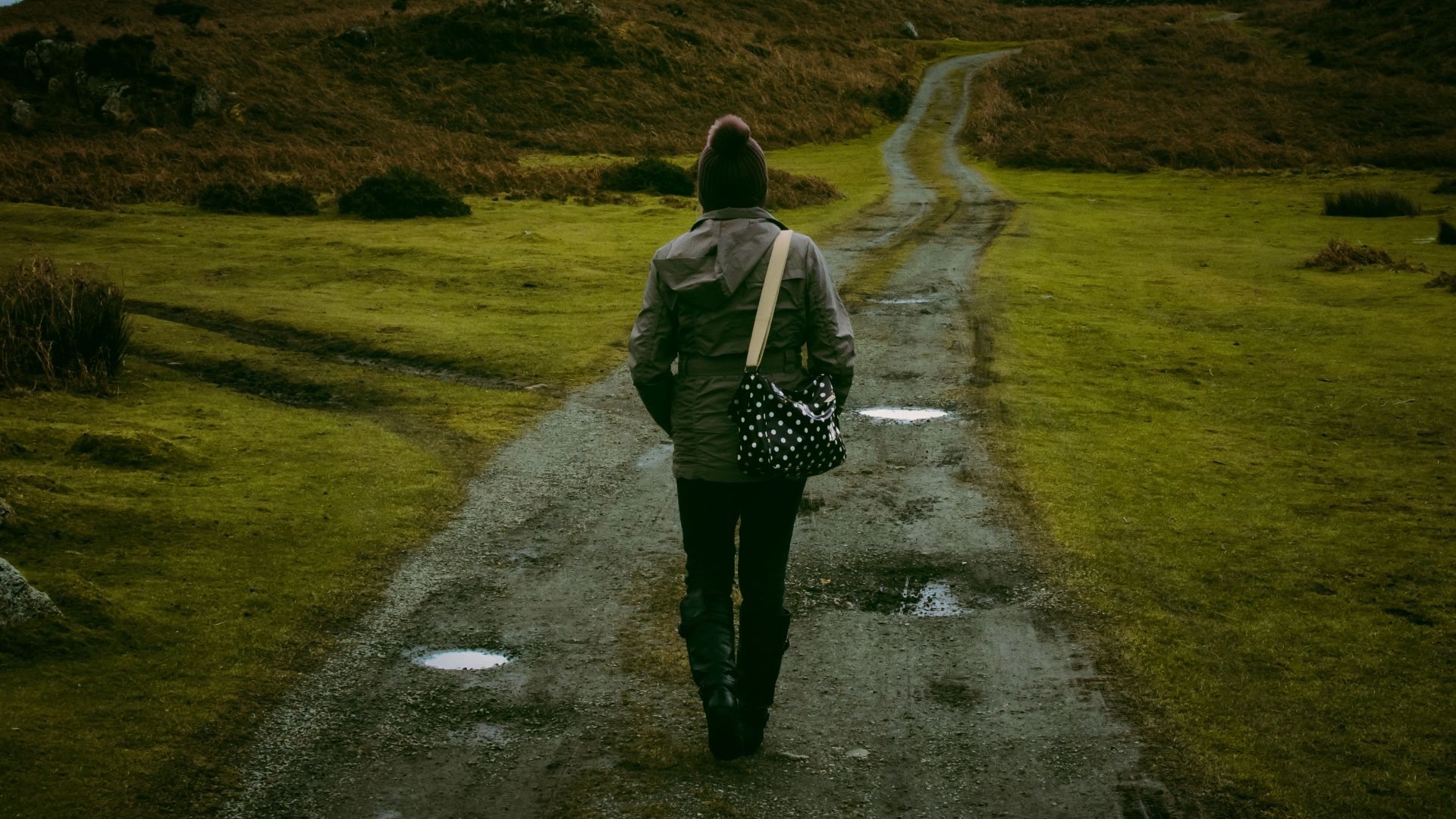 Person walking on a scenic countryside trail, embracing solitude and nature.