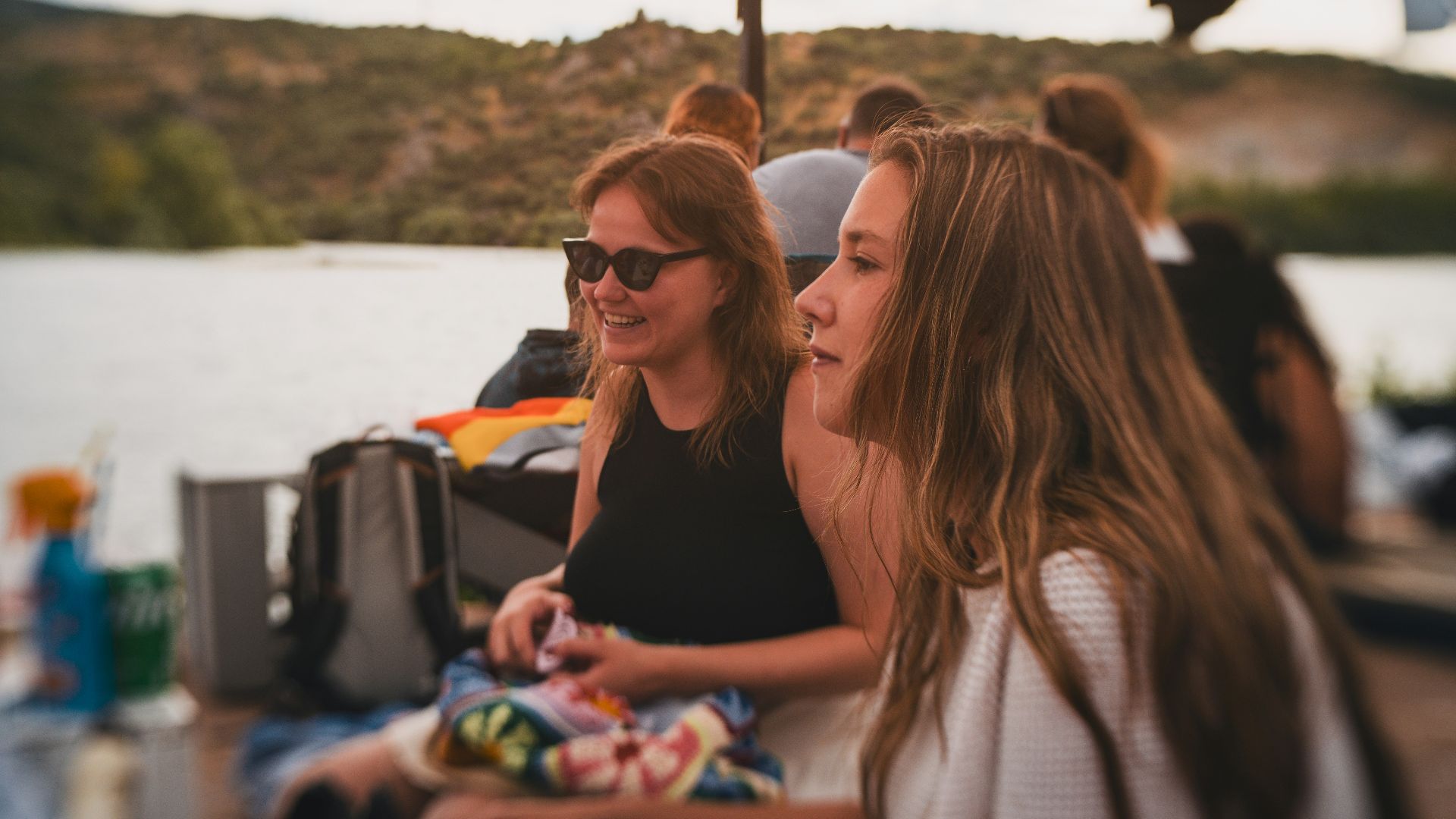 A group of women sitting at a table next to a lake
