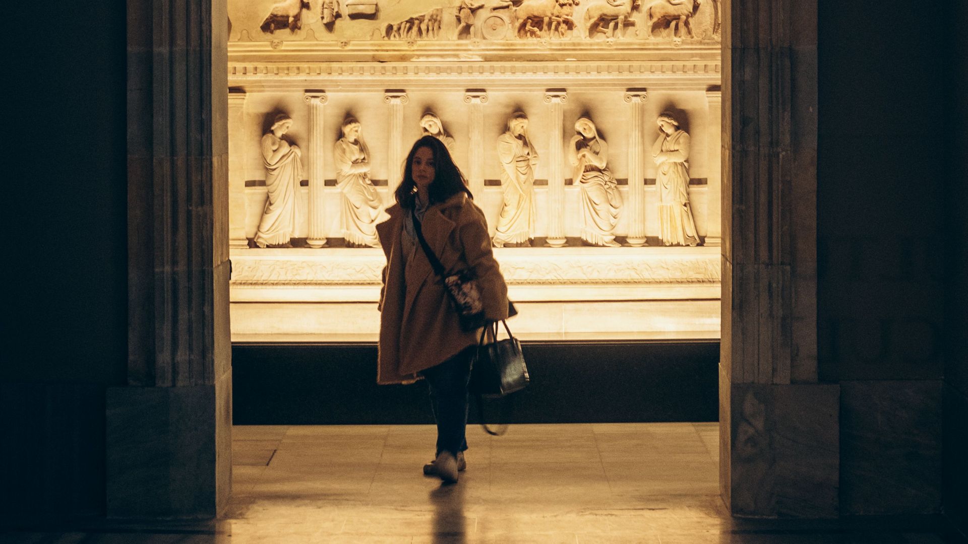 A visitor explores the illuminated exhibition inside Istanbul Archaeology Museum, Turkey.