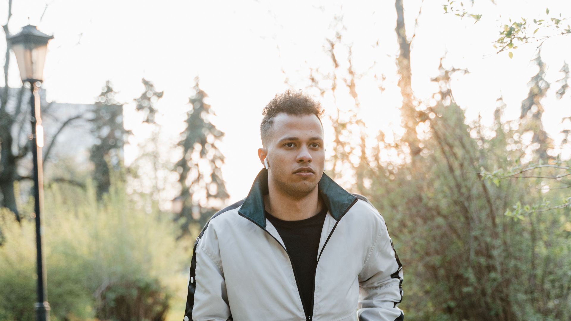 A young man jogging outdoors in a park during sunset, showcasing fitness and an active lifestyle.