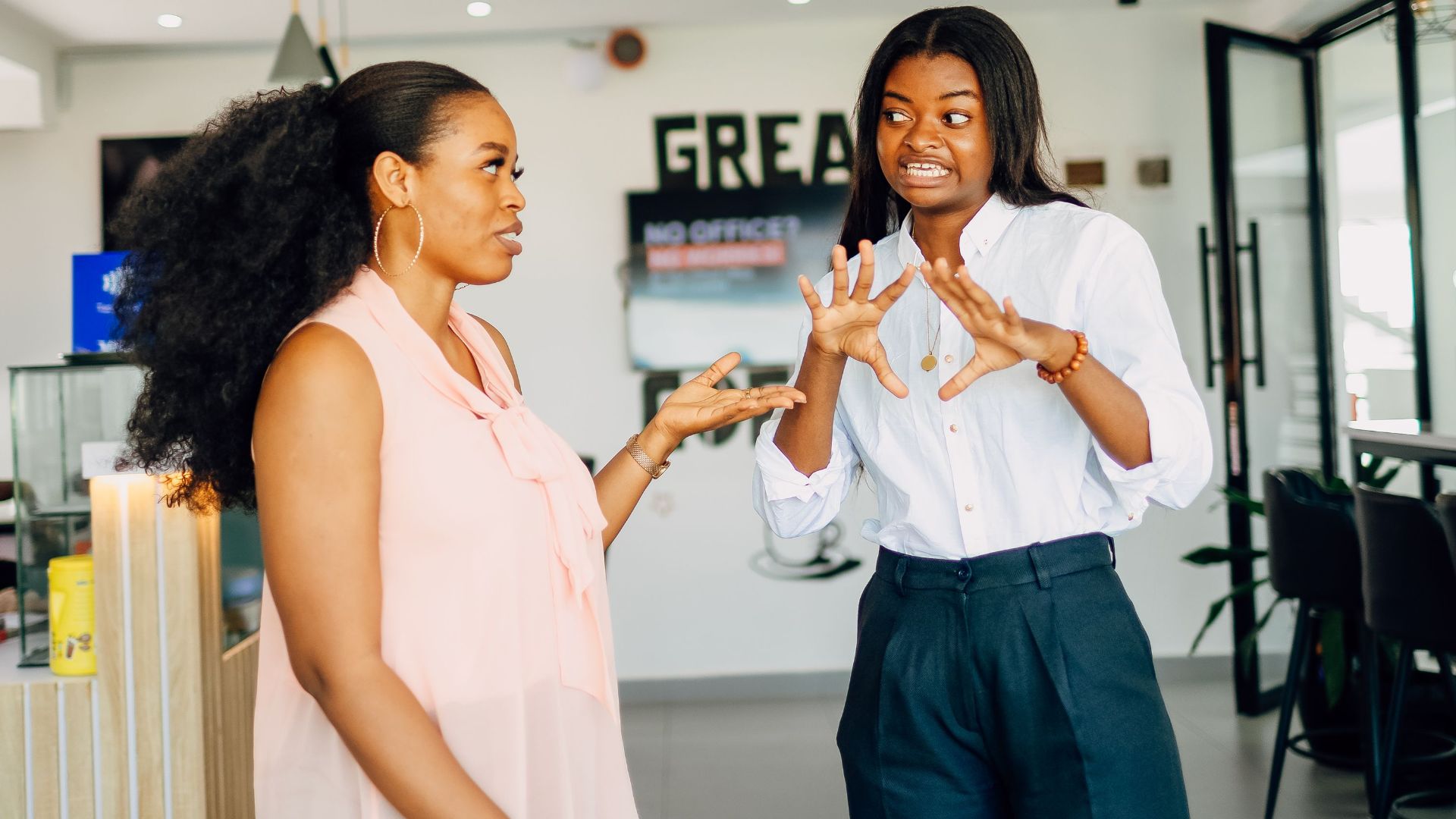 Two women engaging in a vibrant discussion at Café One in Lagos, Nigeria.