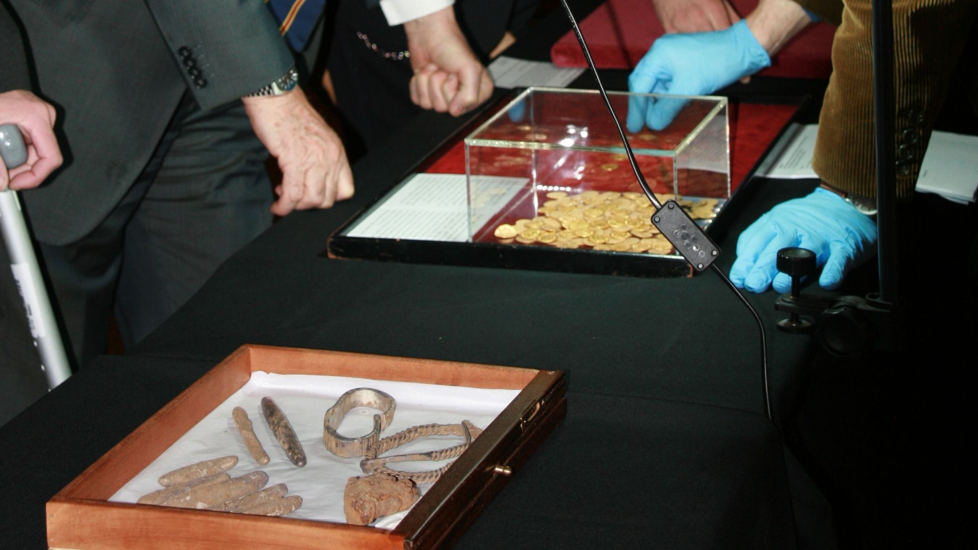 Colin Renfrew, Baron Renfrew of Kaimsthorn looking at gold coins
