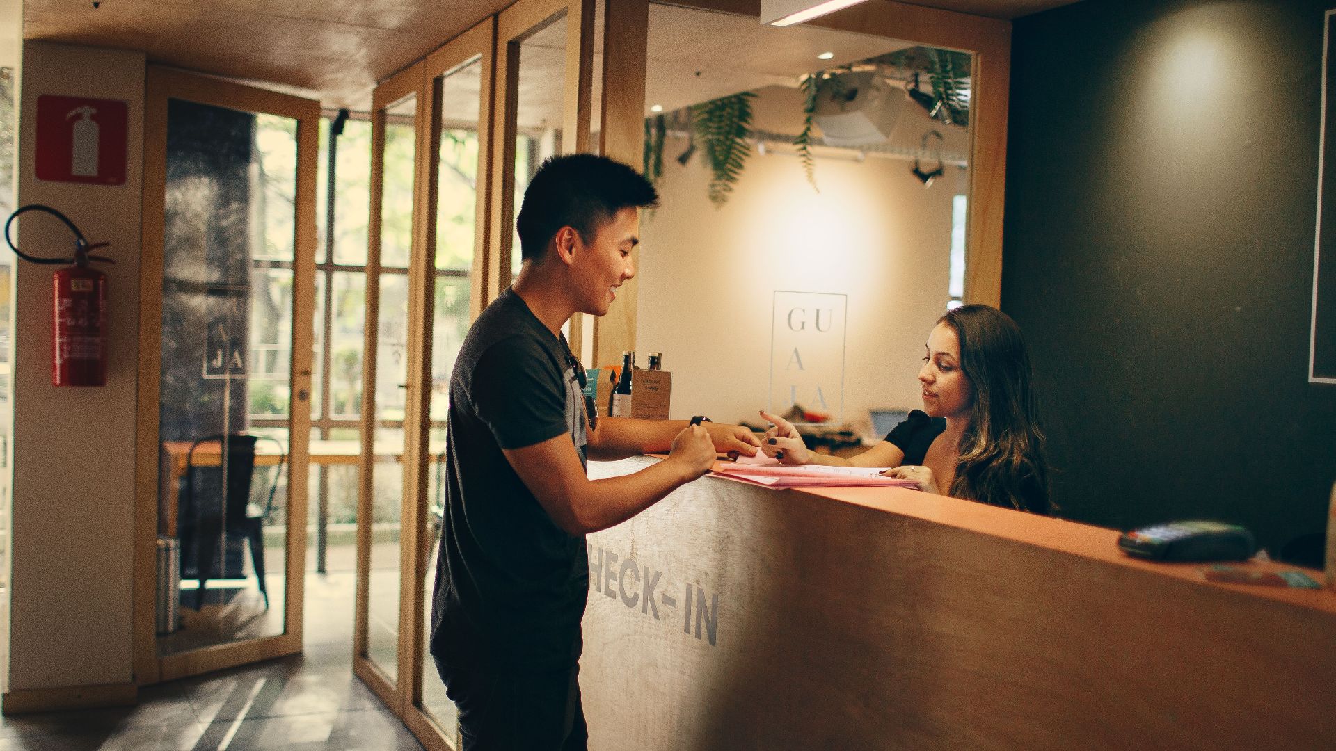A customer checks in at a hotel reception desk in Belo Horizonte, Brazil.