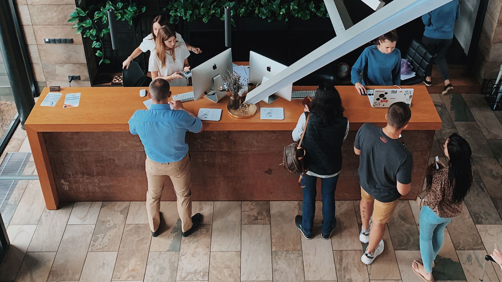 Aerial view of a modern hotel reception with people interacting at the desk in Sosnivka, Ukraine.