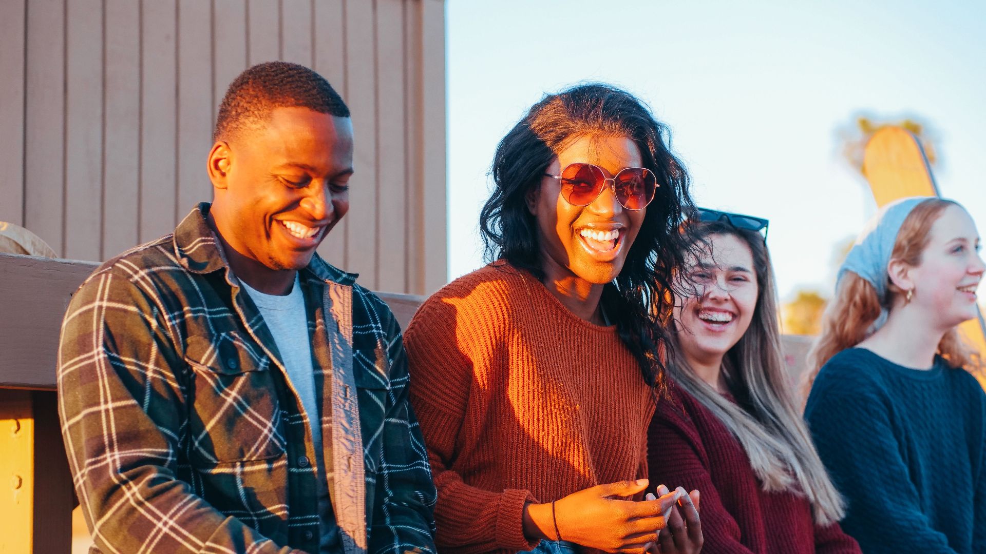 A group of diverse friends enjoy a fun moment at sunset, showcasing joy and friendship.