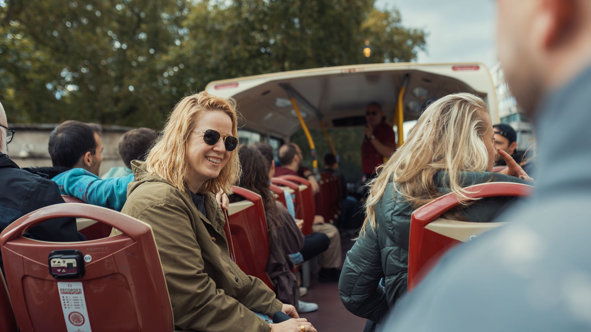 Passengers on an open-top bus enjoying a city tour. Ideal for travel themes.