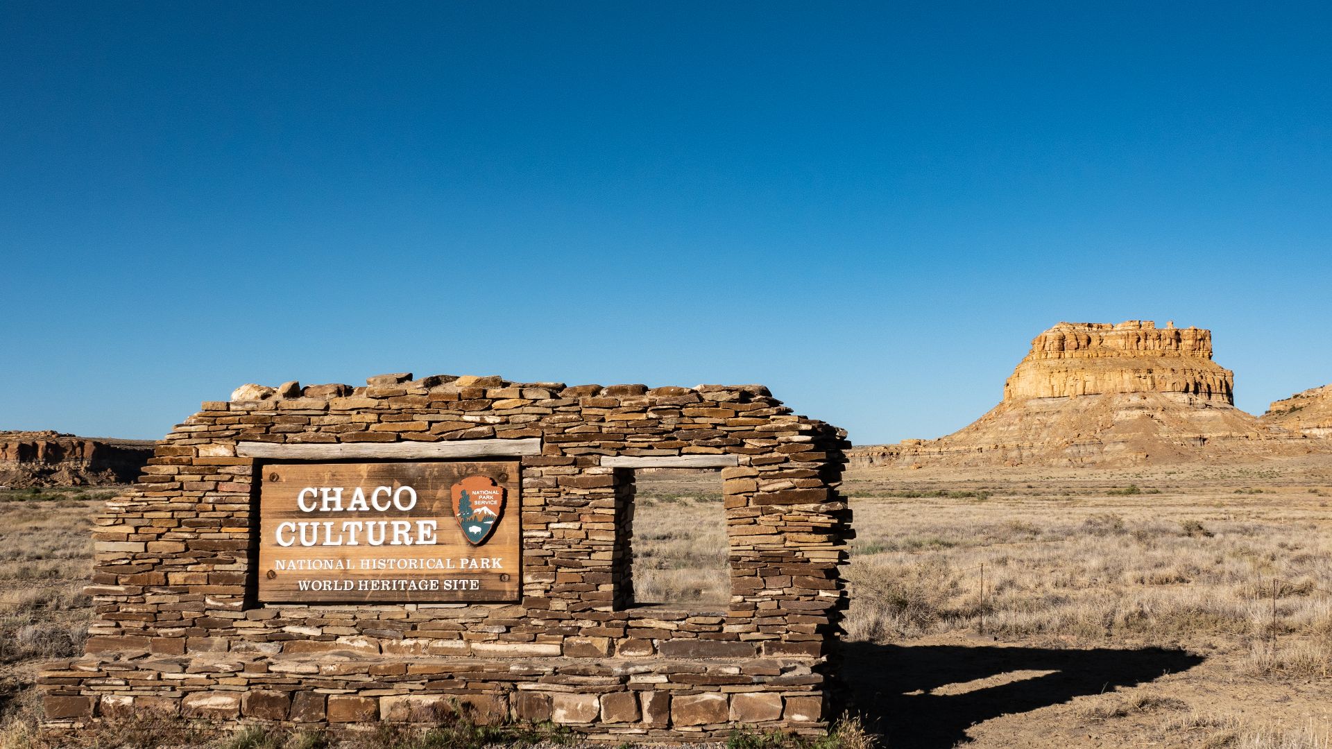 Park entrance sign with Fajada Butte in the background