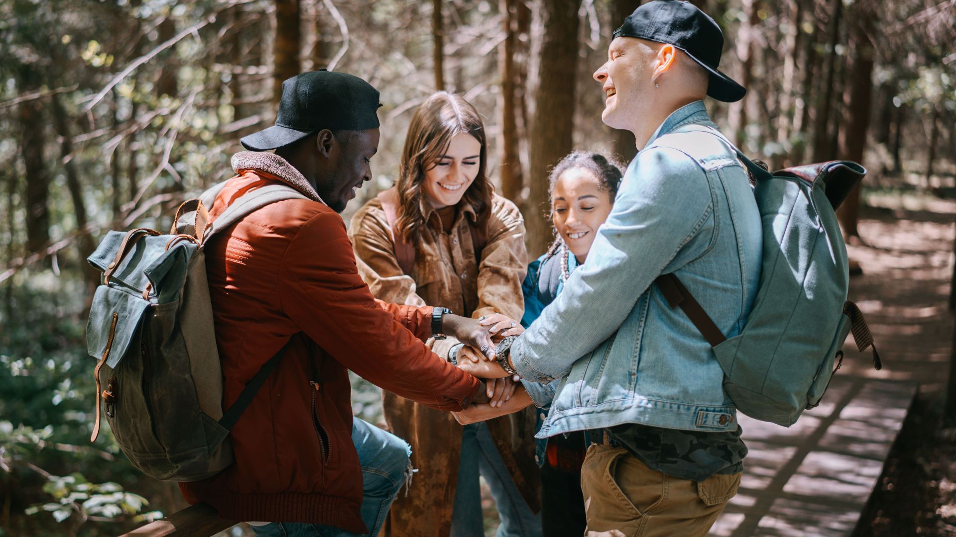Four friends enjoying a hiking trip together in a lush forest setting, sharing smiles and togetherness.