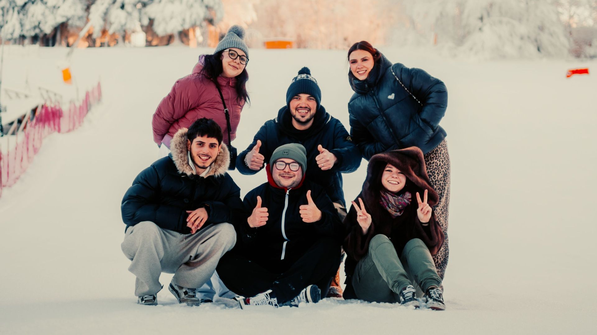 A cheerful group of friends posing in a snowy landscape, creating fun memories.