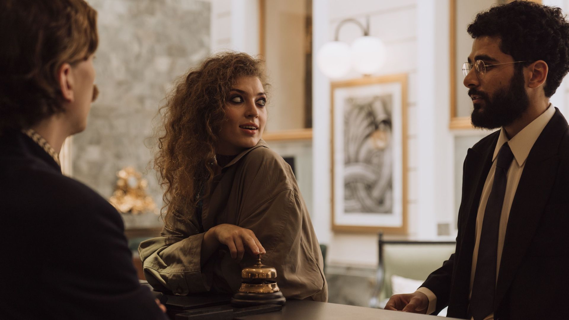 Guests interacting at a luxurious hotel reception desk, emphasizing hospitality and service.