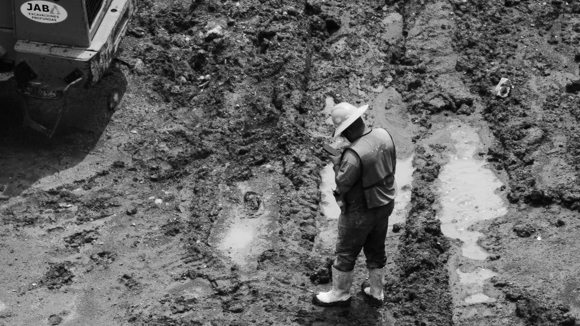 Black and white image of a construction worker on a muddy site in Mexico City from above.