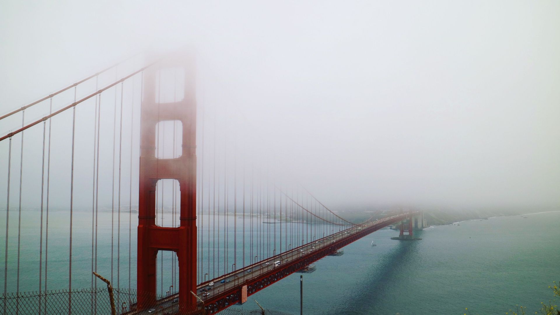 Ethereal view of San Francisco's Golden Gate Bridge shrouded in fog.