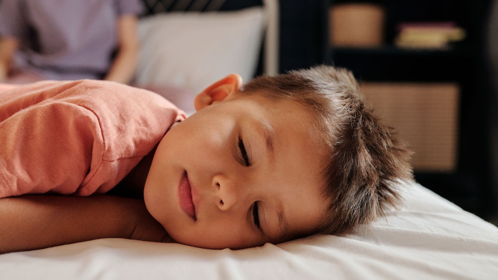 A young child sleeping peacefully in a cozy bedroom setting, embodying tranquility and rest.