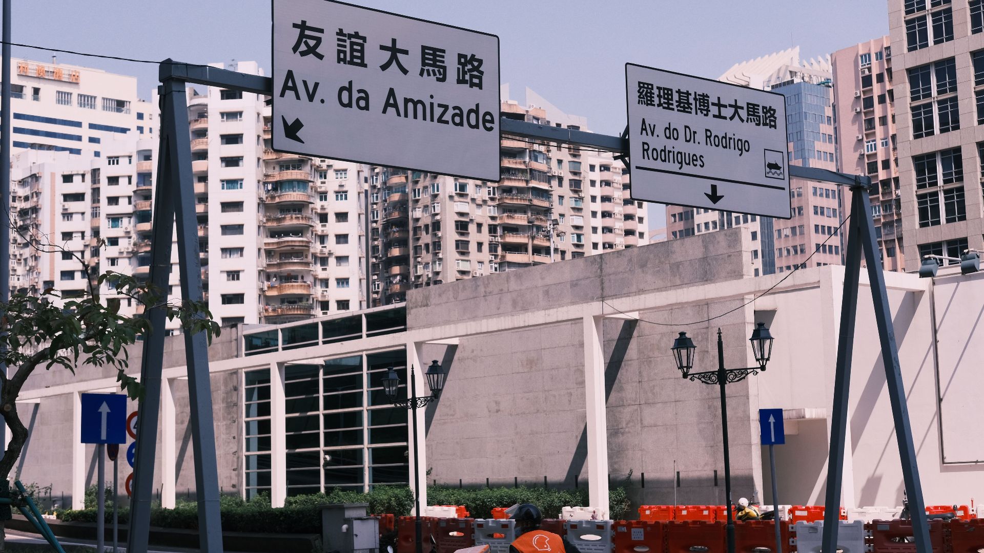 Street view in Macau with bilingual road signs and urban architecture.
