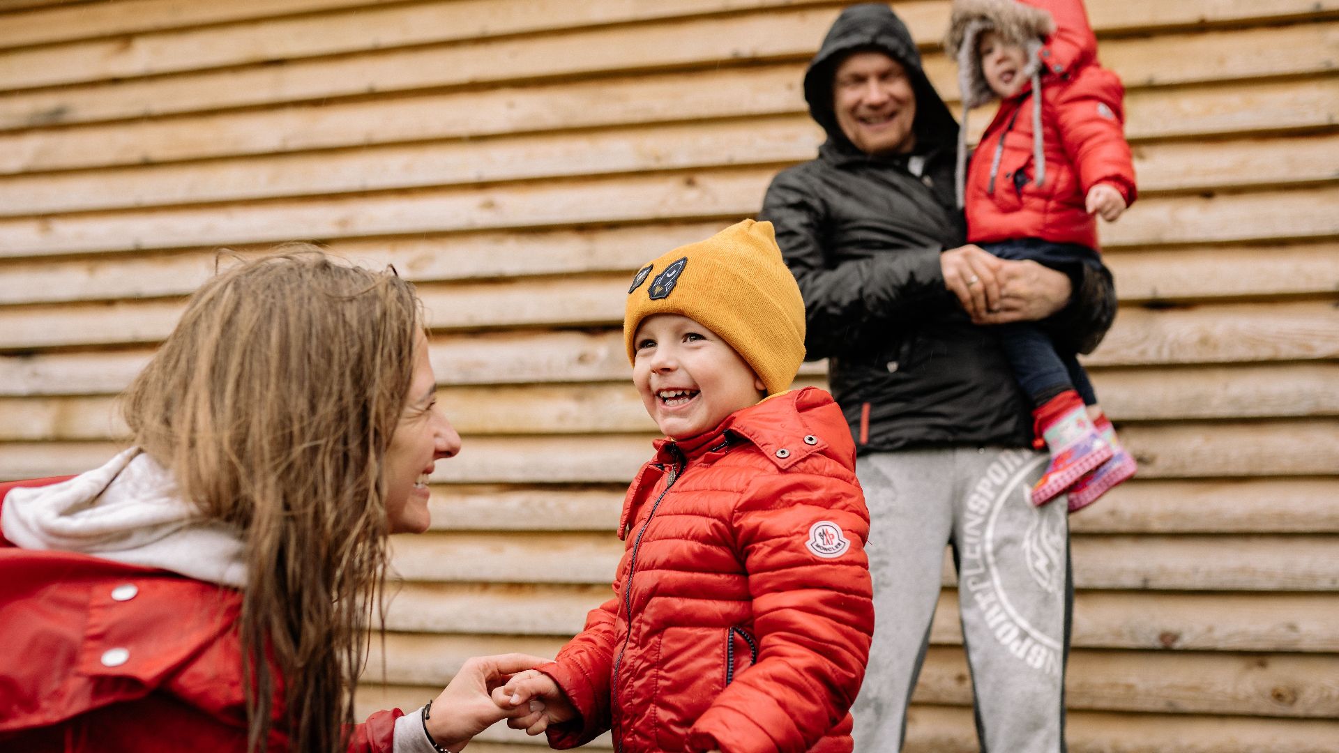 A joyful family enjoying time together outdoors in cozy fall clothing.