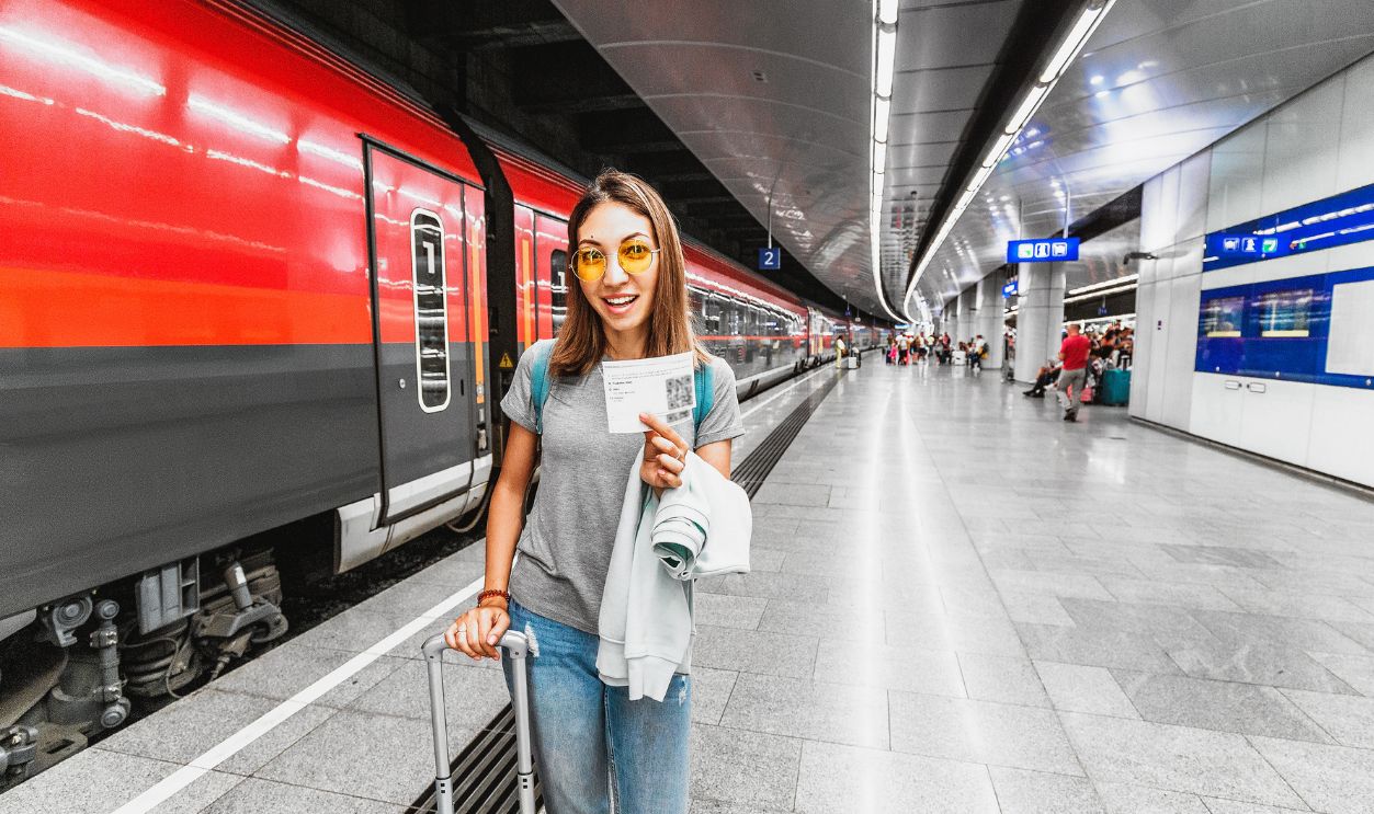 Girl traveler with Luggage and suitcase holding a train or subway ticket with qr-code