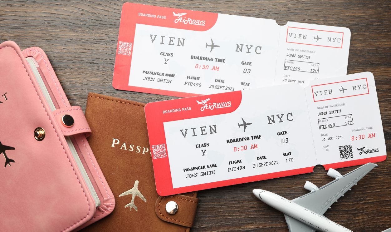 Travel agency. Flight tickets, passports and plane model on wooden table, flat lay