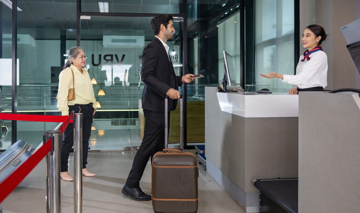 Caucasian businessman passenger is receiving boarding pass from the airline ground crew at check in counter at departure terminal into airplane for final inspection before boarding to plane