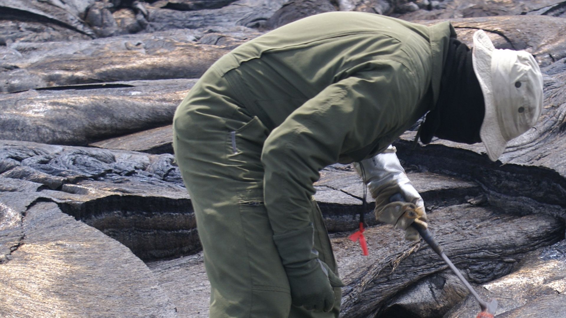 Lava Sampling — USGS geologists at the Hawaiian Volcano Observatory (HVO) still get fresh lava samples as close to the vent as possible. Once the sample is scooped from the pāhoehoe lobe, it is quickly quenched in a bucket of water to stop the growth of a