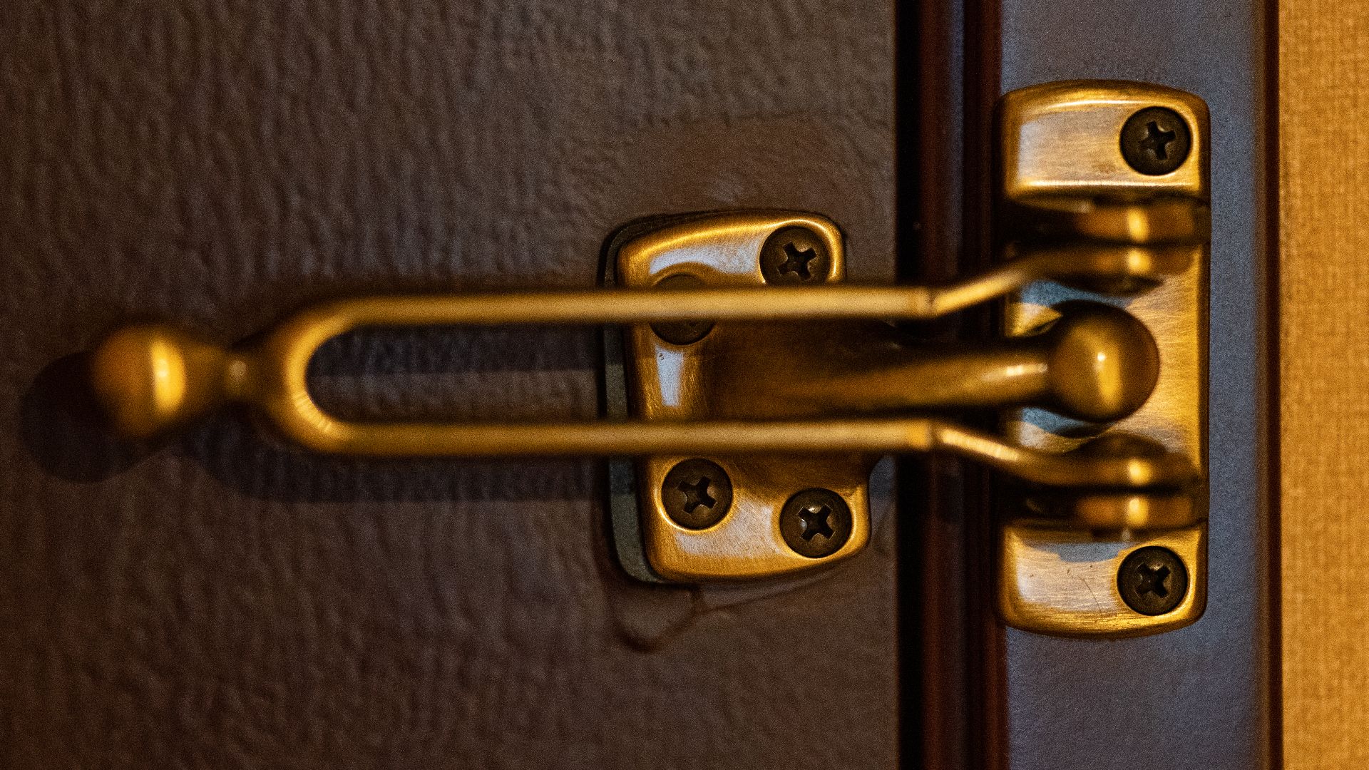 A deadbolt lock on the inside of a hotel room door.