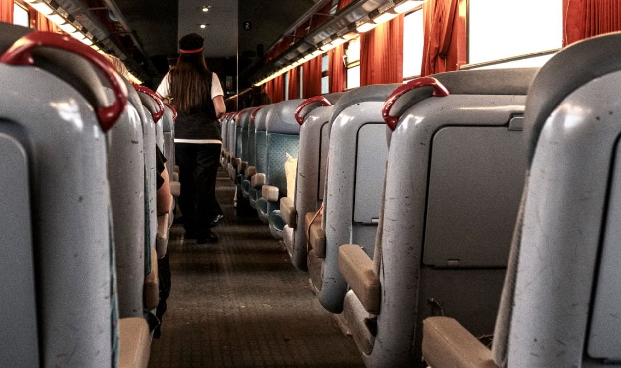 A view of a train interior in France showcasing red curtains and passengers onboard