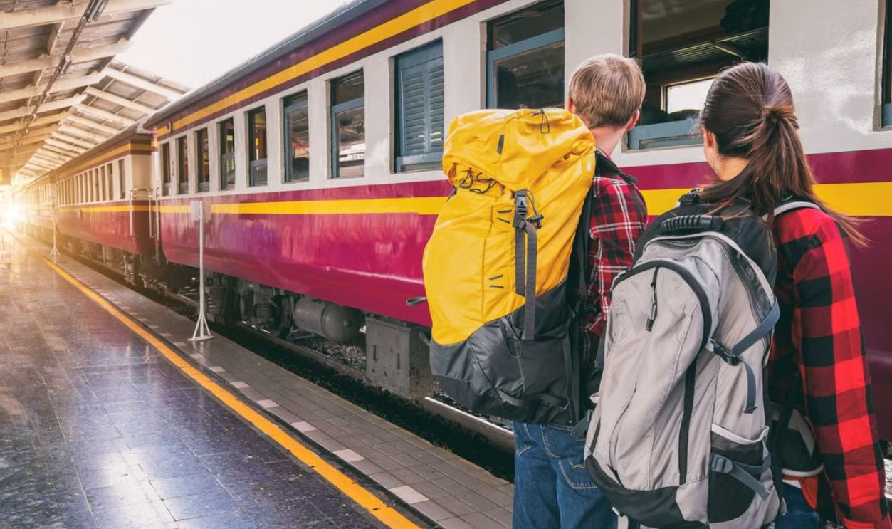 Backpackers waiting at a train station platform, ready for travel adventure
