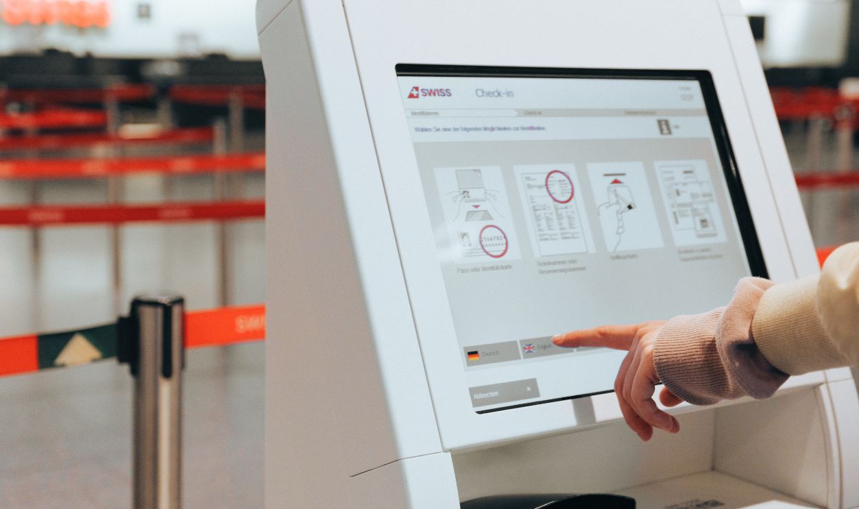 Passenger using self-service check-in kiosk at airport for convenient travel experience