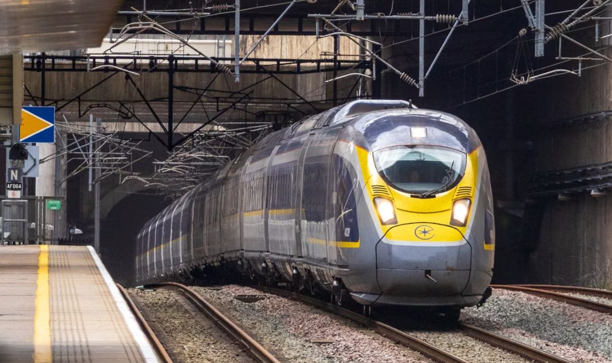 Eurostar high-speed train approaches platform exit from a tunnel, showcasing modern rail travel.