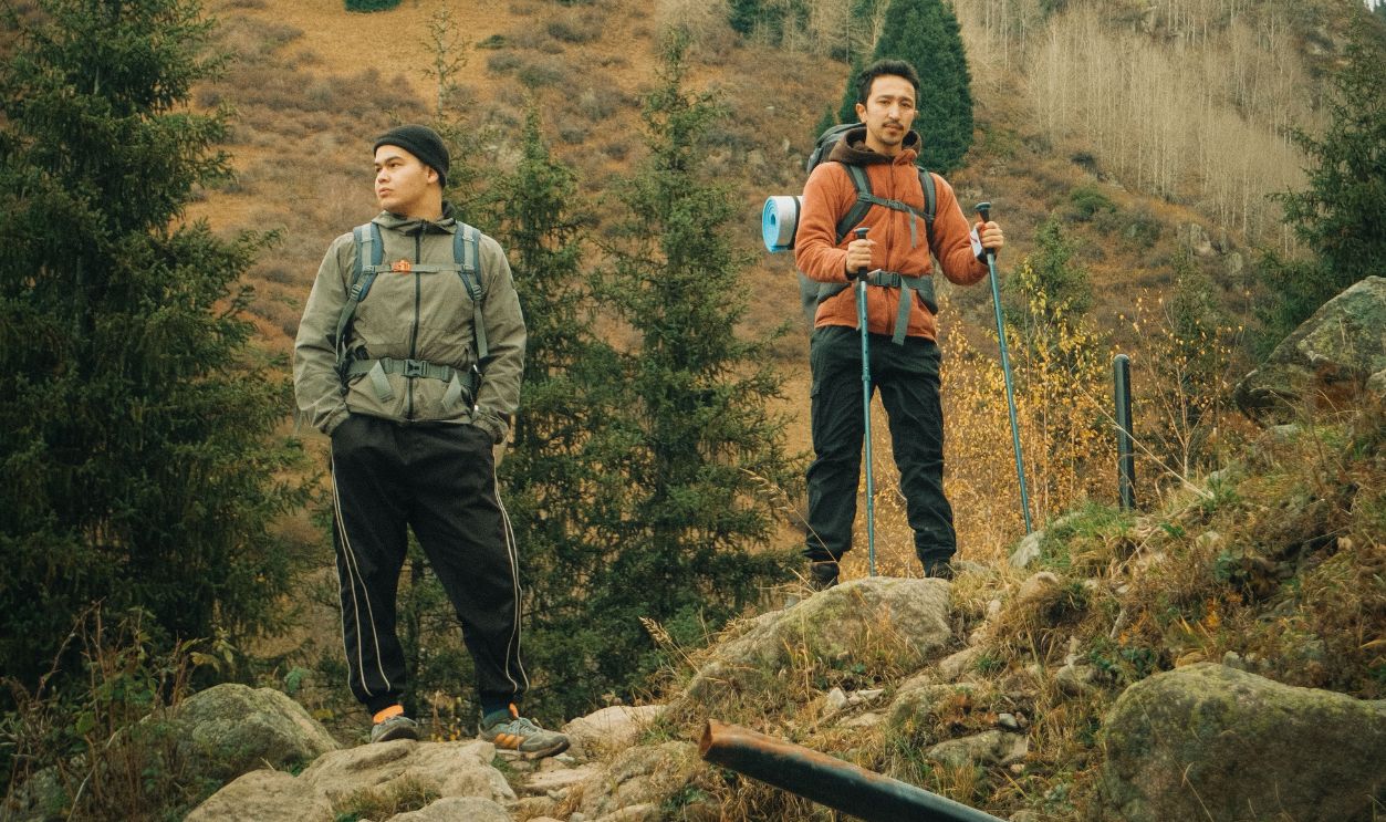 Two hikers with backpacks standing on a scenic mountain trail