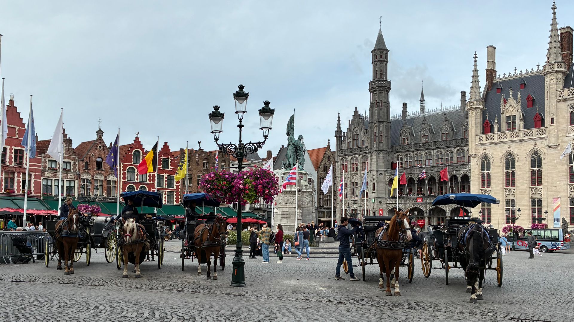 Horse-drawn carriages waiting for tourists at the Markt in Bruges, Belgium.