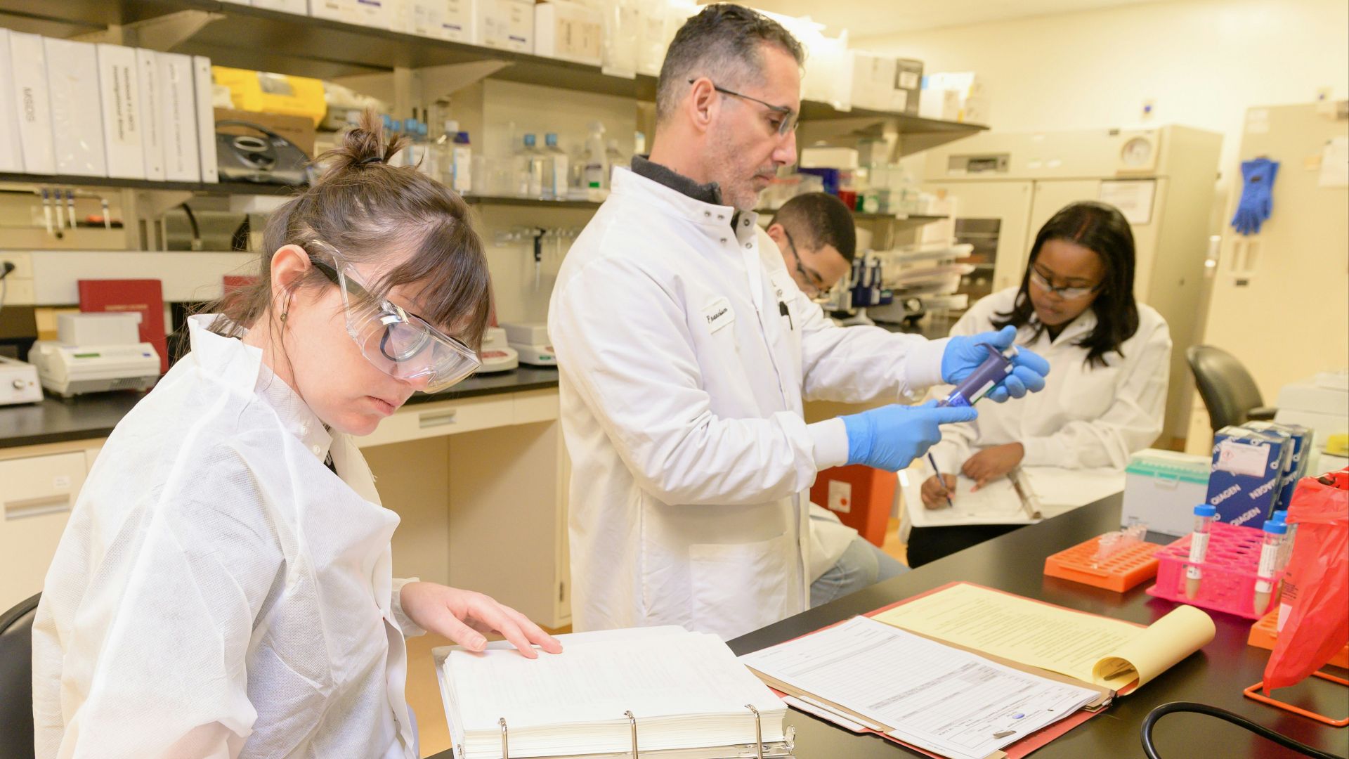 a group of people in lab coats working in a lab