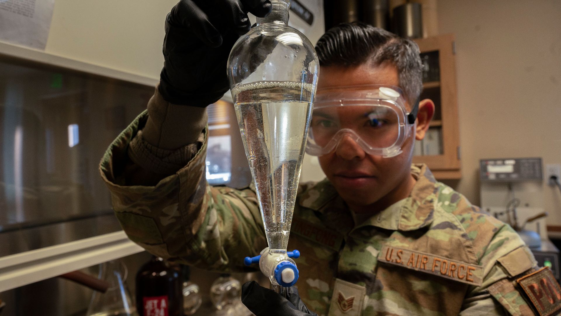 Staff Sgt. Austin Taitingfong, 49th Logistic Readiness Squadron fuels laboratory noncommissioned officer in charge, inspects a flask of jet fuel at Holloman Air Force Base, N.M., Dec. 12, 2022. The 49th LRS fuels laboratory is the first line of defense fo