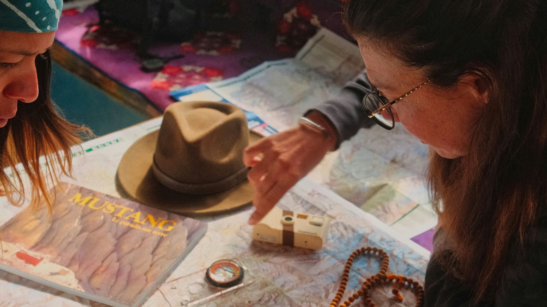 Two women planning a journey, pointing at a detailed map.