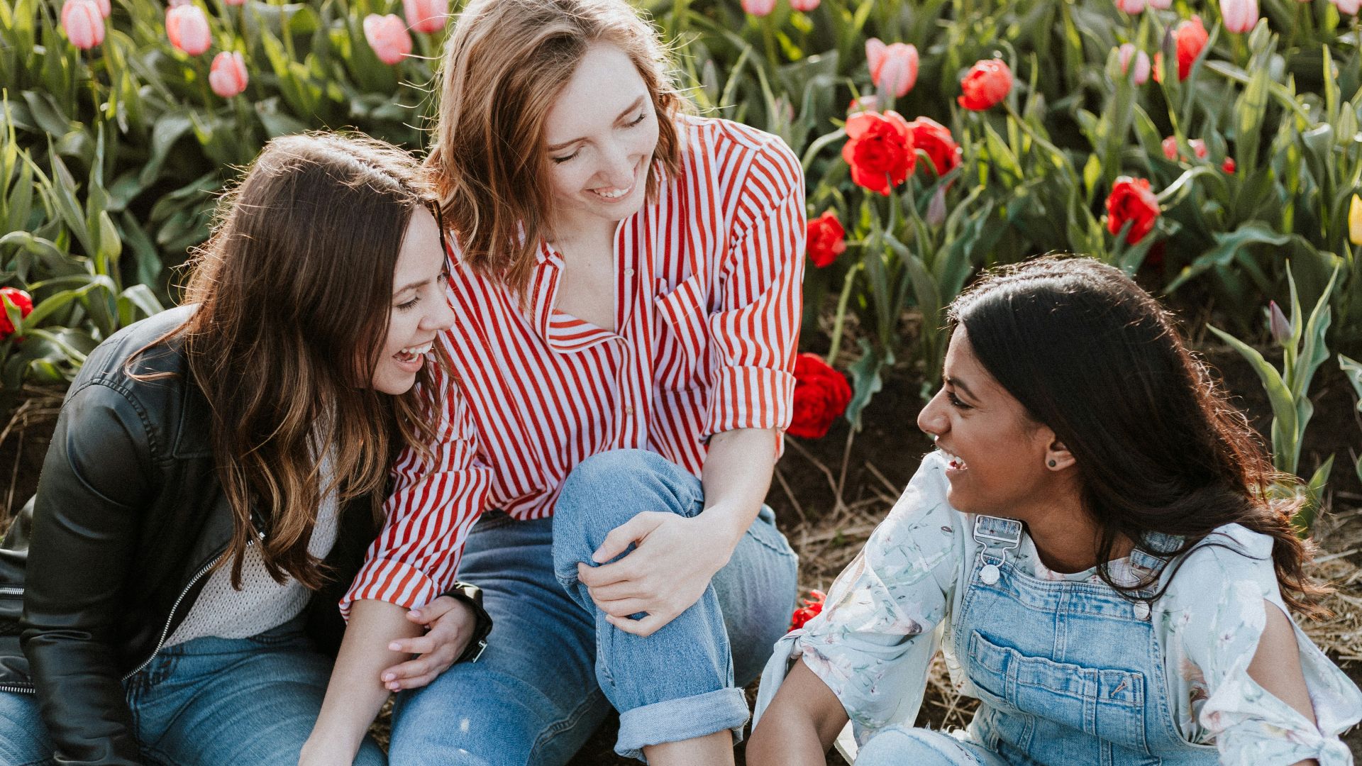 three woman sitting near the flower