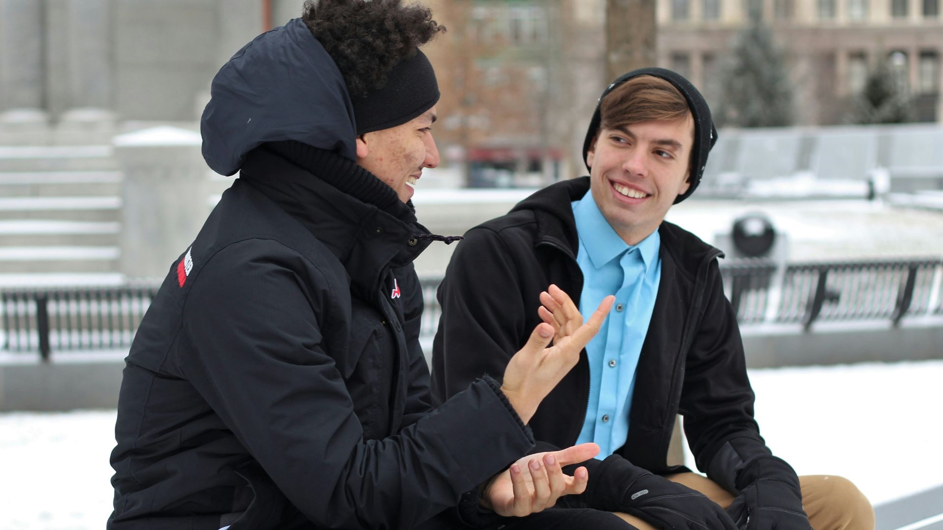 two men talking while sitting on bench