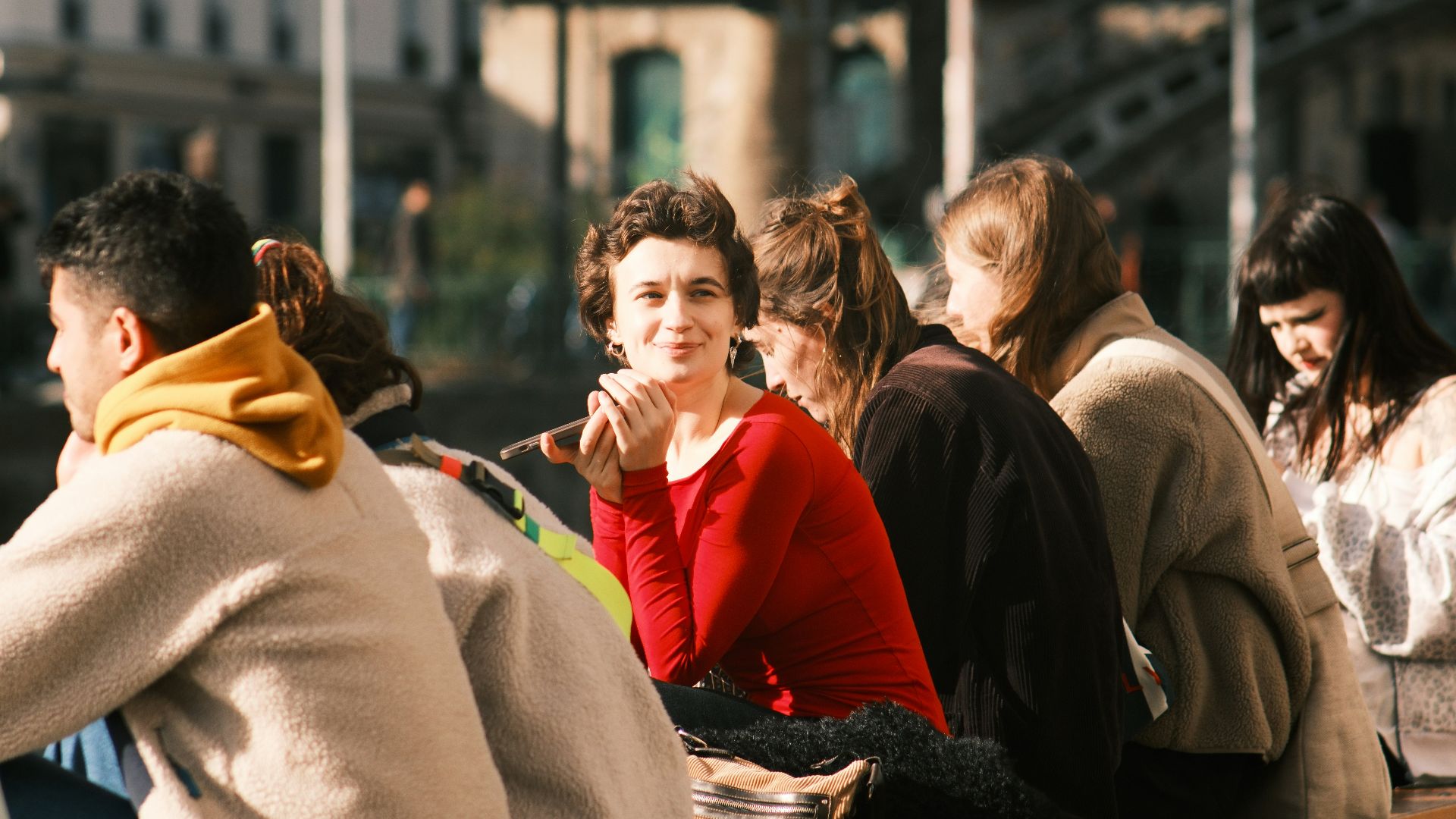 Group of people sitting outdoors on a sunny day.