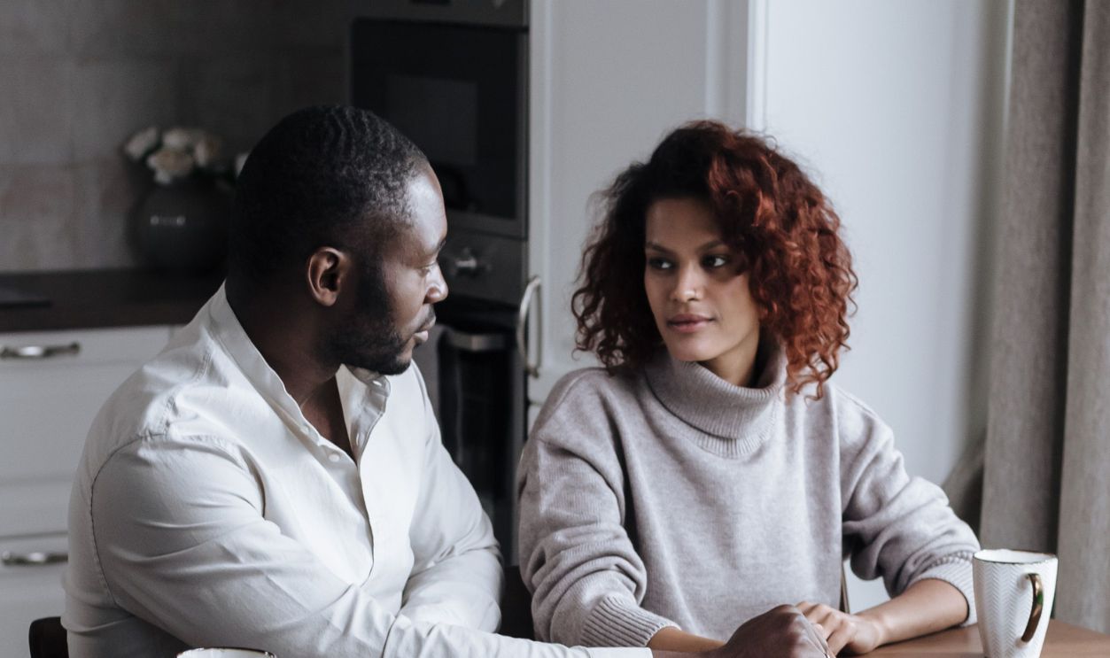 A couple discussing work over a laptop and coffee in a cozy home 
