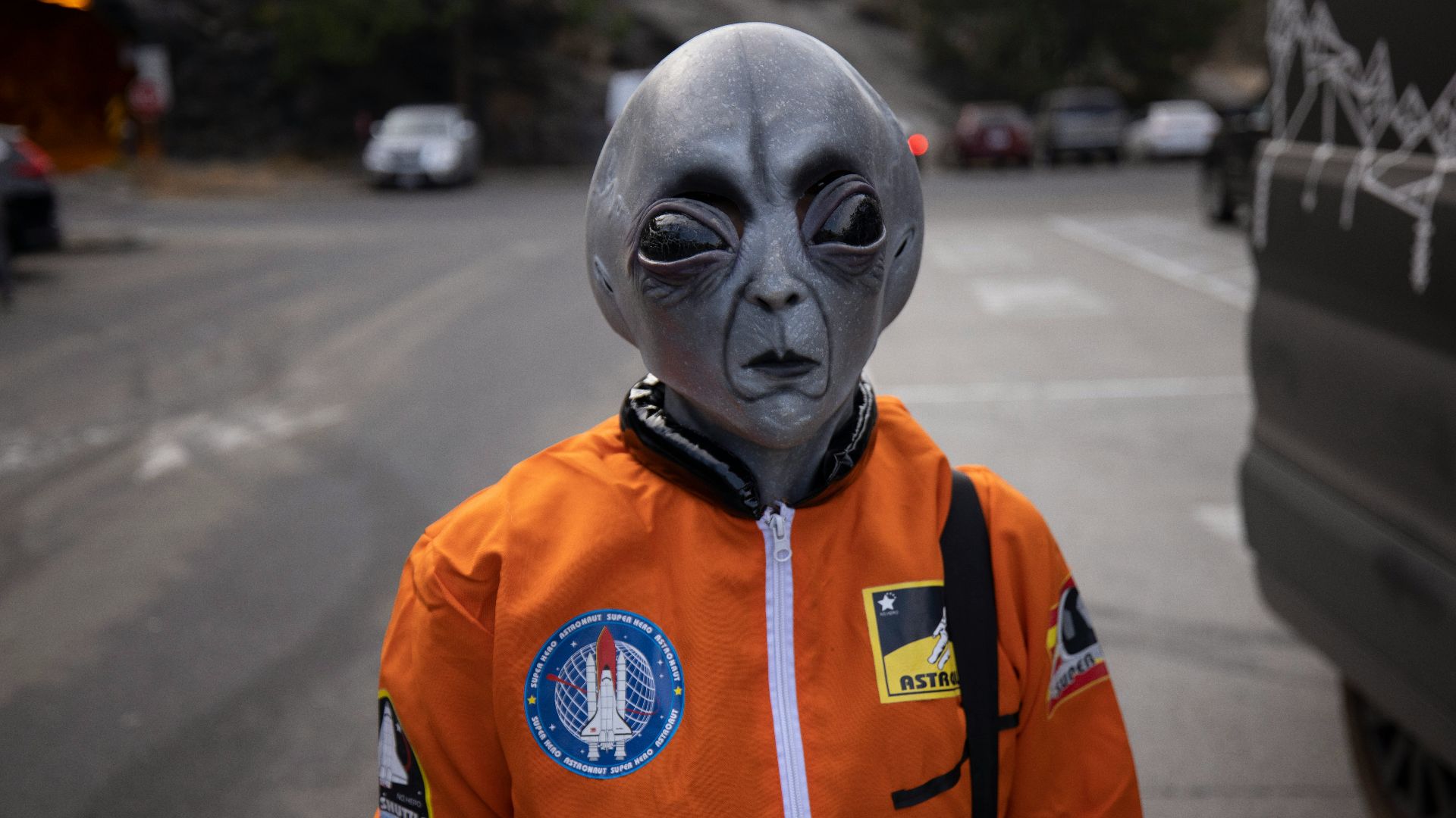 man in orange and white zip up jacket wearing white mask