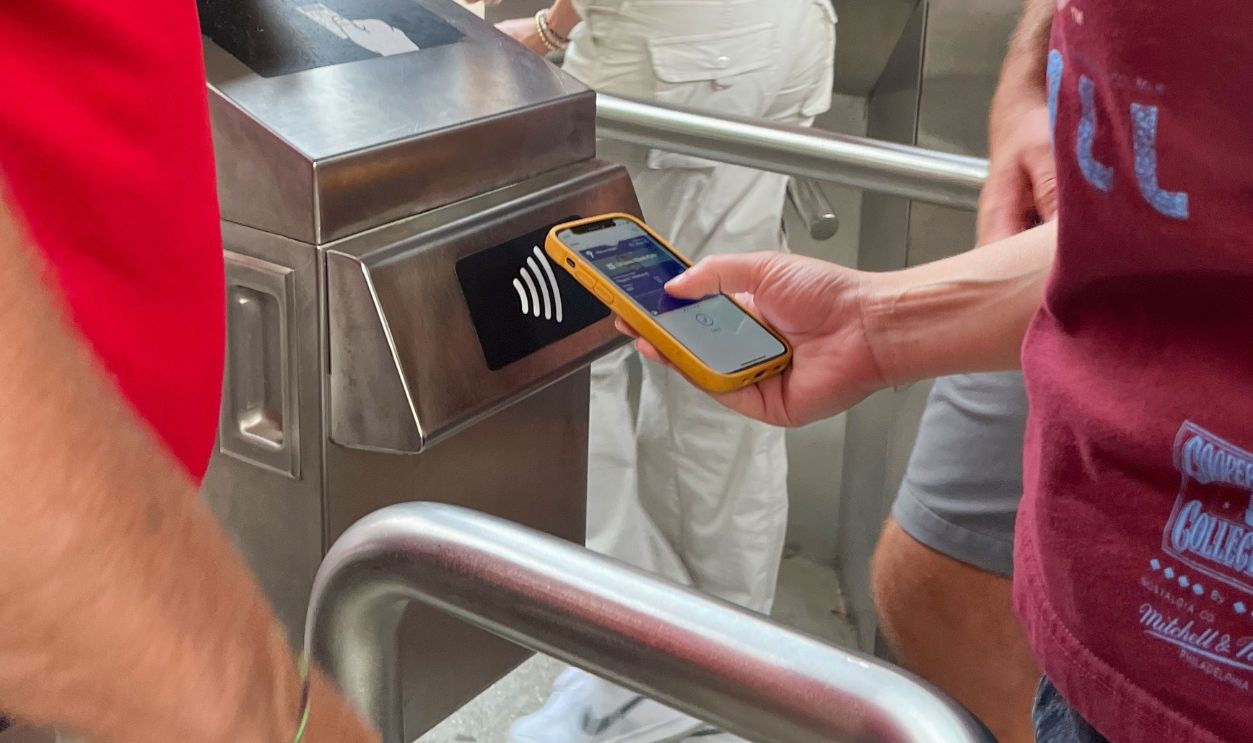 Philadelphia, Pennsylvania. USA - Ago 17th 2024: A man in a red shirt is holding a cell phone and looking at a machine. Ticket verification system at Citizen Bank Park, home of the Philadelphia Philli