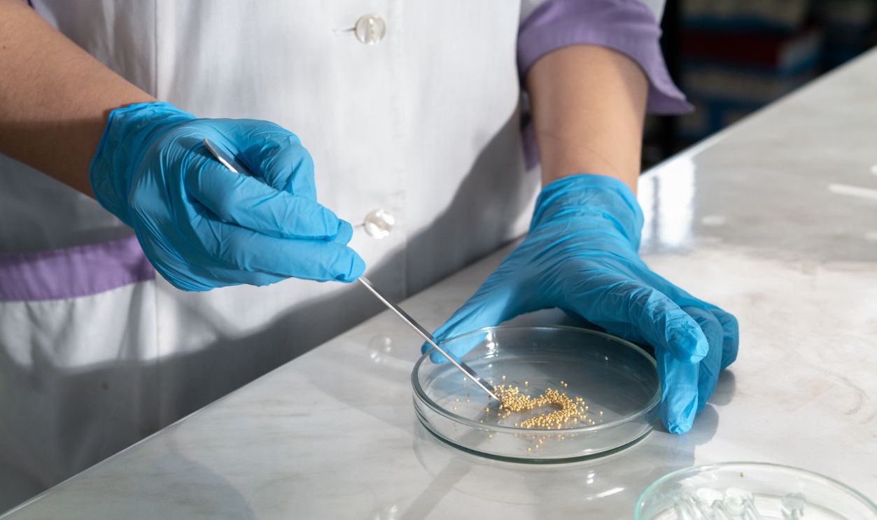 Close-up of a lab technician using a petri dish for research with medical gloves