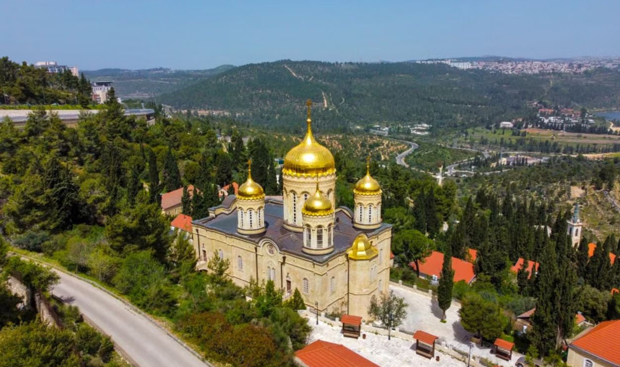 Aerial view of the Russian Orthodox Monastery with golden domes amidst green hills in Jerusalem, Israel