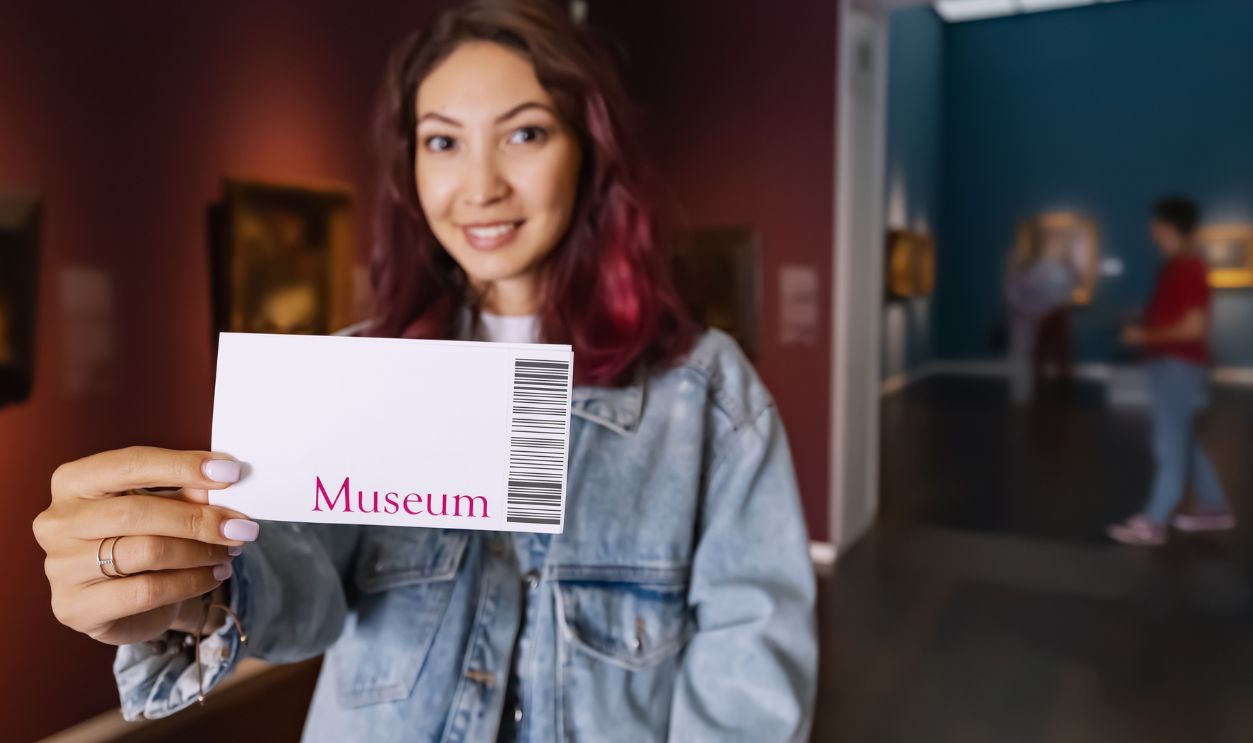 Visitor holding ticket to fine art museum with paintings. Art exhibition and entertainment
